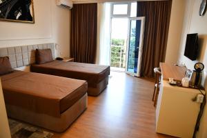 a hotel room with two beds and a sliding glass door at Park Naftalan Sanatoriya Kompleksi in Naftalan +27 photos