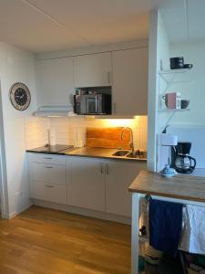 a kitchen with white cabinets and a sink at Snäckbacken Visby in Visby