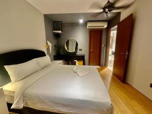 a bedroom with a large white bed with a mirror at Vortex suites klcc by Kualalampur vibes in Kuala Lumpur +3 photos