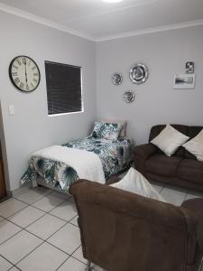 a living room with a bed and a clock on the wall at The Gather Inn Bethlehem in Bethlehem
