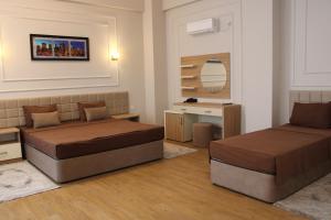 a bedroom with two beds and a desk and a mirror at Park Naftalan Sanatoriya Kompleksi in Naftalan