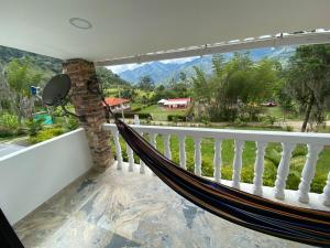 un hamac sur un balcon avec vue sur les montagnes dans l'établissement Piscina Privada, Zona parrillas, 8 min del Pueblo, Parqueadero Cubierto, à Pacho