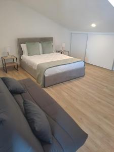 a bedroom with a large bed and wooden floors at Sky and Sea Haven in São Pedro