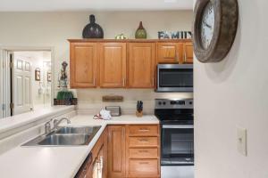 a kitchen with a sink and a clock on the wall at Fairway To Heaven - For 8ppl in Branson West