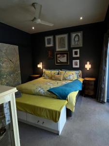 a bedroom with a large bed and pictures on the wall at Franschhoek Guest Suite in Franschhoek