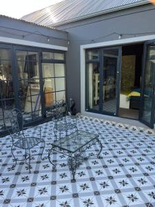 a patio with a table and chairs on a tiled floor at Franschhoek Guest Suite in Franschhoek