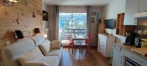 a living room with a couch and a table at studio Loubat pyrénée, ménage inclus in Arette