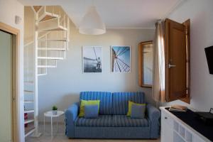 a living room with a blue couch and a staircase at Riva Sea Apartments in Castellammare del Golfo