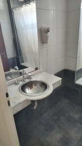 un baño con lavabo y espejo en Colina Garden departamento, en Victoria