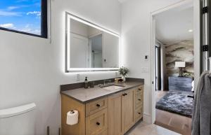 ein Badezimmer mit Waschbecken und Spiegel in der Unterkunft Modern Jackson Getaway Near Town Square in Jackson