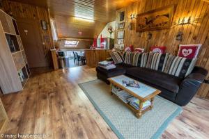 a living room with a couch and a table at Das Gîte Fleuri Mit Einer Herrlichen Aussicht in Hazelbourg