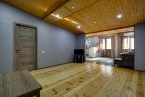 a living room with a wooden floor and a wooden ceiling at Aleqs in Tbilisi City