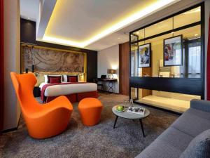 a hotel room with a bed and a couch at Grand Hôtel La Cloche Dijon - MGallery Collection in Dijon