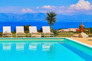 a pool with chairs and a view of the water at VILLA ANANDA in Scopello