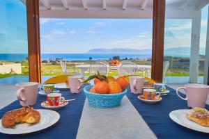 a blue table with plates of food and croissants and oranges at VILLA ANANDA in Scopello