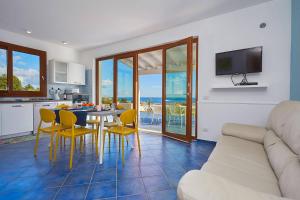 a kitchen and living room with a table and chairs at VILLA ANANDA in Scopello