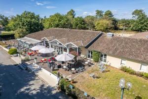 an aerial view of a house with tables and umbrellas at Au P'tit Creux des Landes in Ychoux