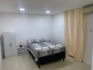 a bedroom with a bed in a white room at Hotel Renascer pojuca in Pojuca