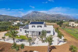 an aerial view of a white house with palm trees at Villa Biancolilla in Castellammare del Golfo