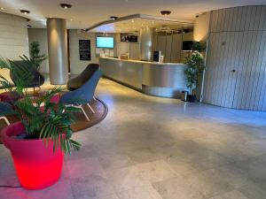 a lobby with a waiting area with a potted plant at Mercure Port La Grande Motte in La Grande-Motte +84 photos