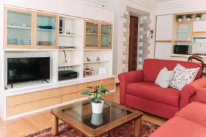 Una sala de estar con un sofá rojo y un televisor. en Palladio Apartment - In Centro con Garage, Vista Fiume, Jacuzzi, en Vicenza 47 fotos más