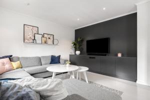 ein Wohnzimmer mit Sofa und Fernseher in der Unterkunft Feriehus med stort lekerom in Kristiansand