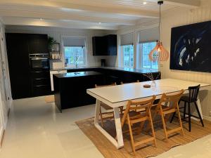 eine Küche mit einem weißen Tisch und Stühlen in der Unterkunft Feriehus med stort lekerom in Kristiansand