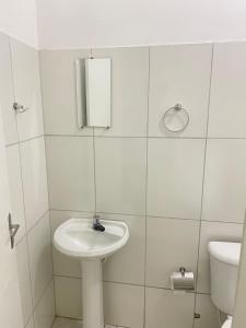 a white bathroom with a sink and a toilet at Hotel Renascer pojuca in Pojuca +8 photos