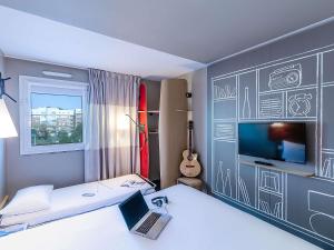 Habitación con cama con ordenador portátil y TV en Hotel ibis Porto Gaia, en Vila Nova de Gaia