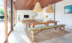 une salle à manger avec une table et des bancs en bois dans l'établissement Amazing 3BDR-Villa Canggu/Seseh 2min walk to Beach, à Canggu