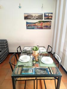 une table en verre avec des chaises et des assiettes dessus dans l'établissement Sori e Mare Loft, à Sori