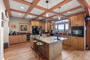 a kitchen with wooden cabinets and a large island with bar stools at 818Forever in Lignite