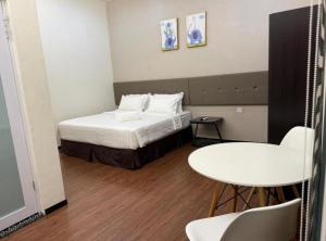 ein kleines Zimmer mit einem Bett und einem Tisch in der Unterkunft King's Lane in Ipoh