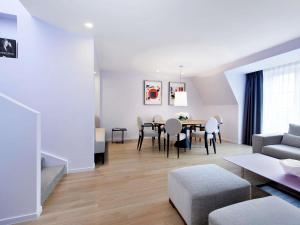 a living room and dining room with a table and chairs at Sofitel Paris Arc De Triomphe in Paris +81 photos