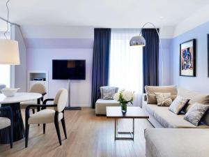 a living room with a couch and a table at Sofitel Paris Arc De Triomphe in Paris