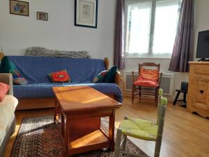 ein Wohnzimmer mit einem blauen Sofa und Stühlen in der Unterkunft Charmant 3 pièces au cœur de Villard-de-Lans avec Wi-Fi - FR-1-515-195 in Villard-de-Lans