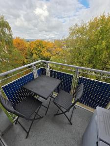 une table et deux chaises sur un balcon dans l'établissement Cozy city apartment Neuwied, à Neuwied