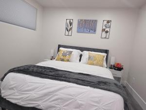 a bedroom with a large white bed with pillows at Cozy Haven Suite in Moncton