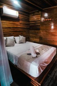 a bedroom with a large bed with wooden walls at Cabaña Kokkos Del Mar in Santa Marta