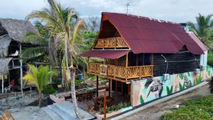 a house with a red roof with a mural on it at Cabaña Kokkos Del Mar in Santa Marta