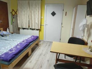 a bedroom with a bed and a table and a door at Apartman LALI in Veľký Meder +26 photos