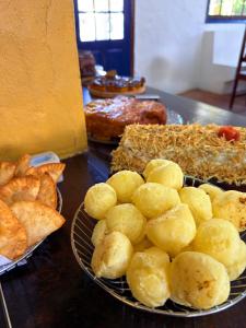 una mesa cubierta con platos de pan y bollería en Pousada Puerta Del Sol Rio das Ostras, en Rio das Ostras