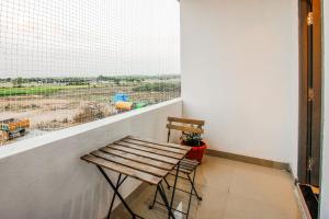 a balcony with two wooden stools and a window at Hotel O D' Jade in Hyderabad