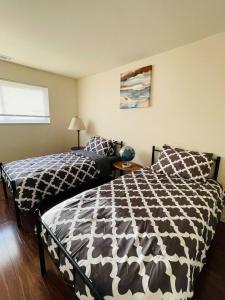 a bedroom with a bed with a black and white comforter at Spacious 2br2ba With Hardwood Floors in Cheltenham Village