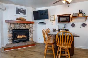 Una sala de estar con chimenea y una mesa y sillas. en (A110) Studio Condominiums, en Yosemite West