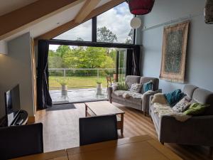 Una sala de estar con dos sofás y una gran ventana. en Cointree, en Sturminster Newton