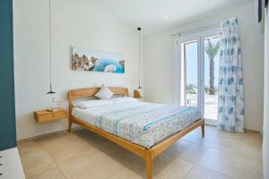 Un dormitorio con una cama y una ventana grande. en VILLA DEL BORGO con piscina e jacuzzi, en Scopello 25 fotos más