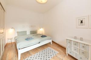 a white bedroom with a white bed and a dresser at Altstadt Residenz in Bernkastel-Kues