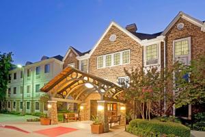 a large brick building with an archway in a courtyard at Staybridge Suites Irving Las Colinas by IHG in Irving
