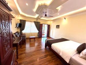 a bedroom with a bed and a desk and a couch at Almond Villa in Kappil